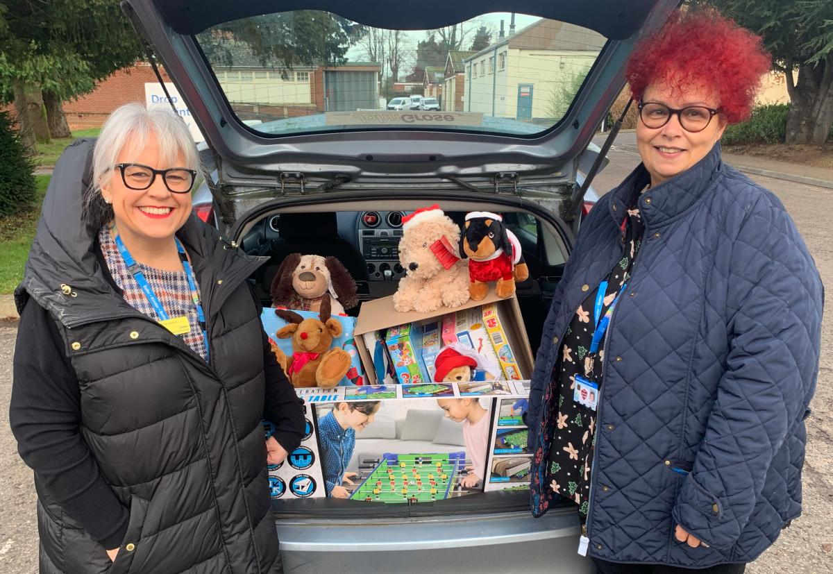 Dawn Collins and Debs Ellis standing beside a car, boot open, full of toys